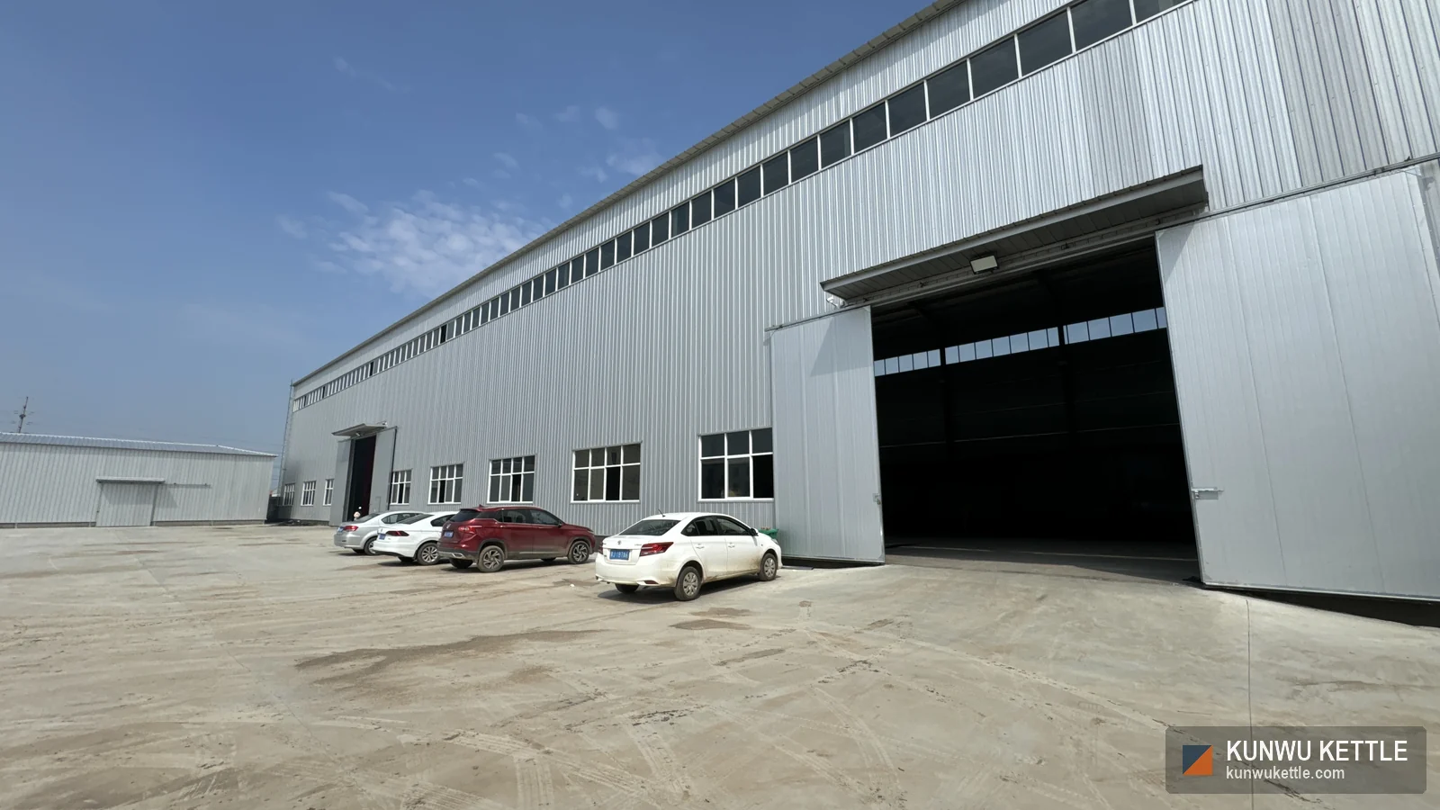 Steel-framed fabrication hall exterior at the manufacturing facility