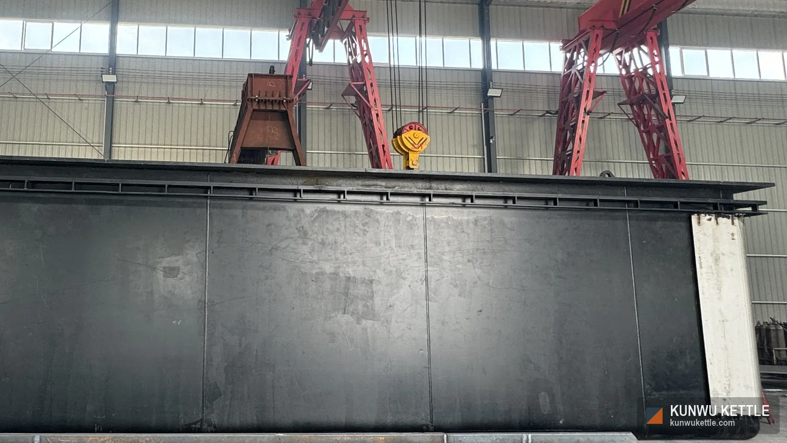Full length galvanizing kettle shell with a double flange top edge under the workshop gantry