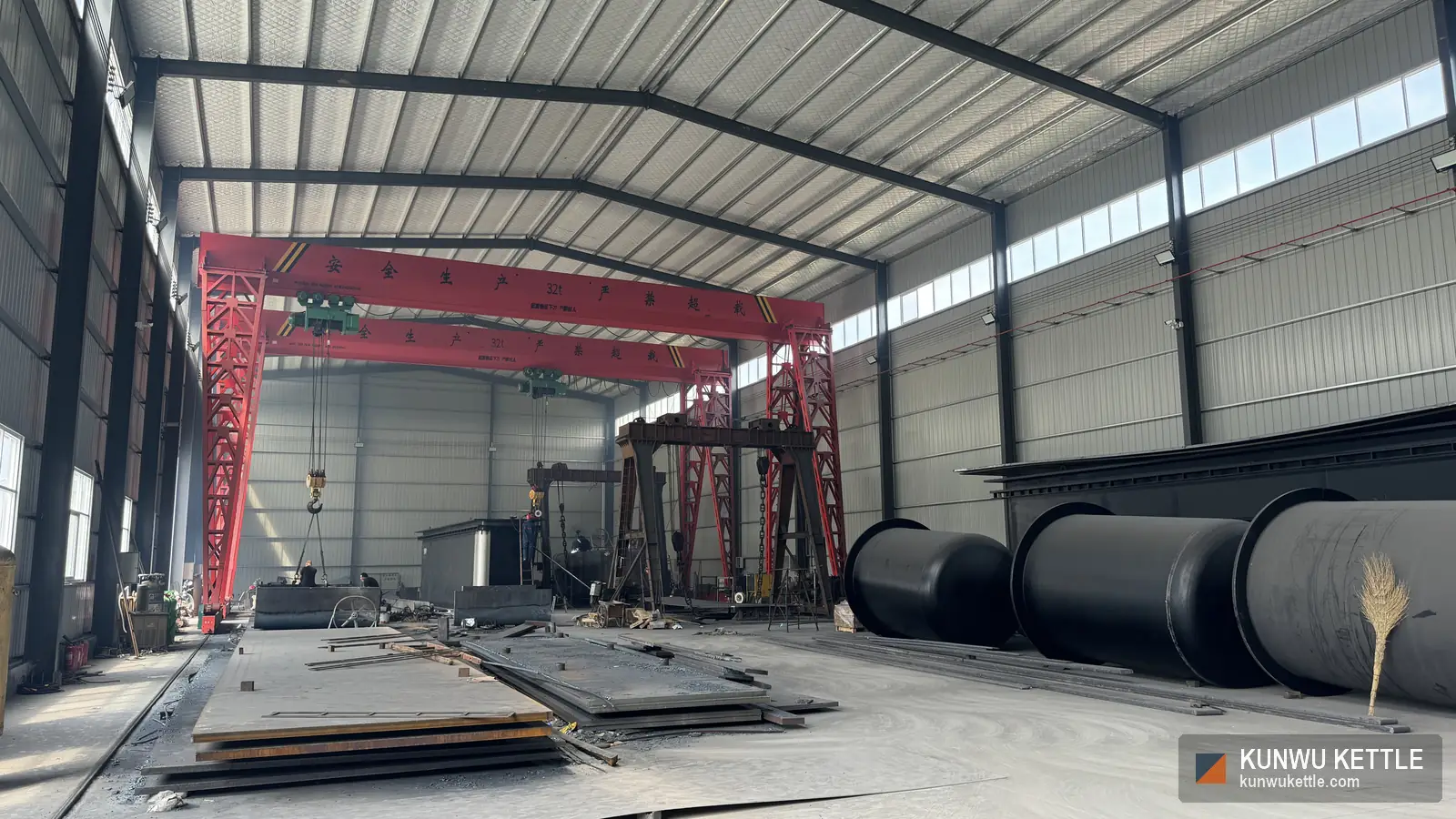 Fabrication bay with red overhead gantry crane rated 32 tonnes and stacked steel plate